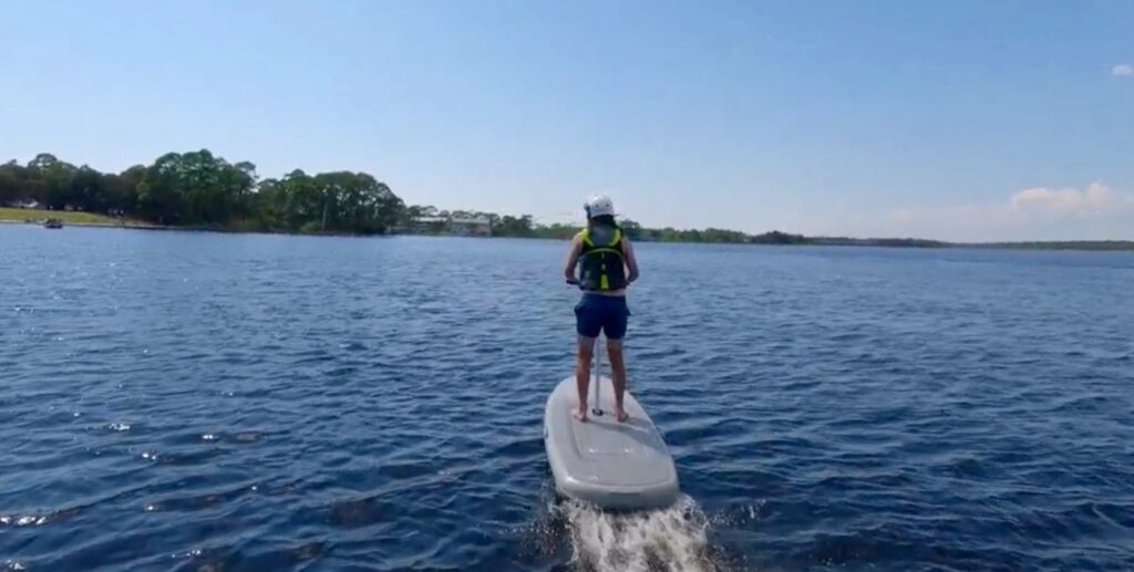 man standing up on efoil at the lake