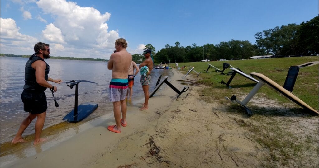 men and efoils on the land next to water