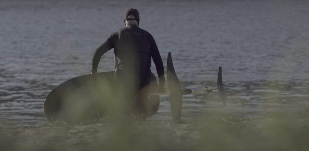 man getting in water to go efoiling