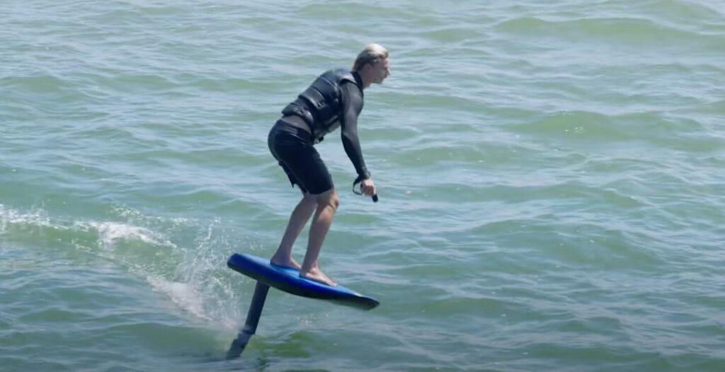 man riding an efoil at the beach