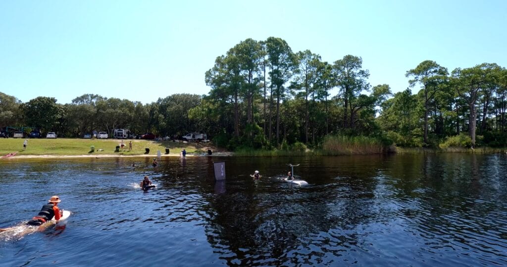 people in the lake on efoils