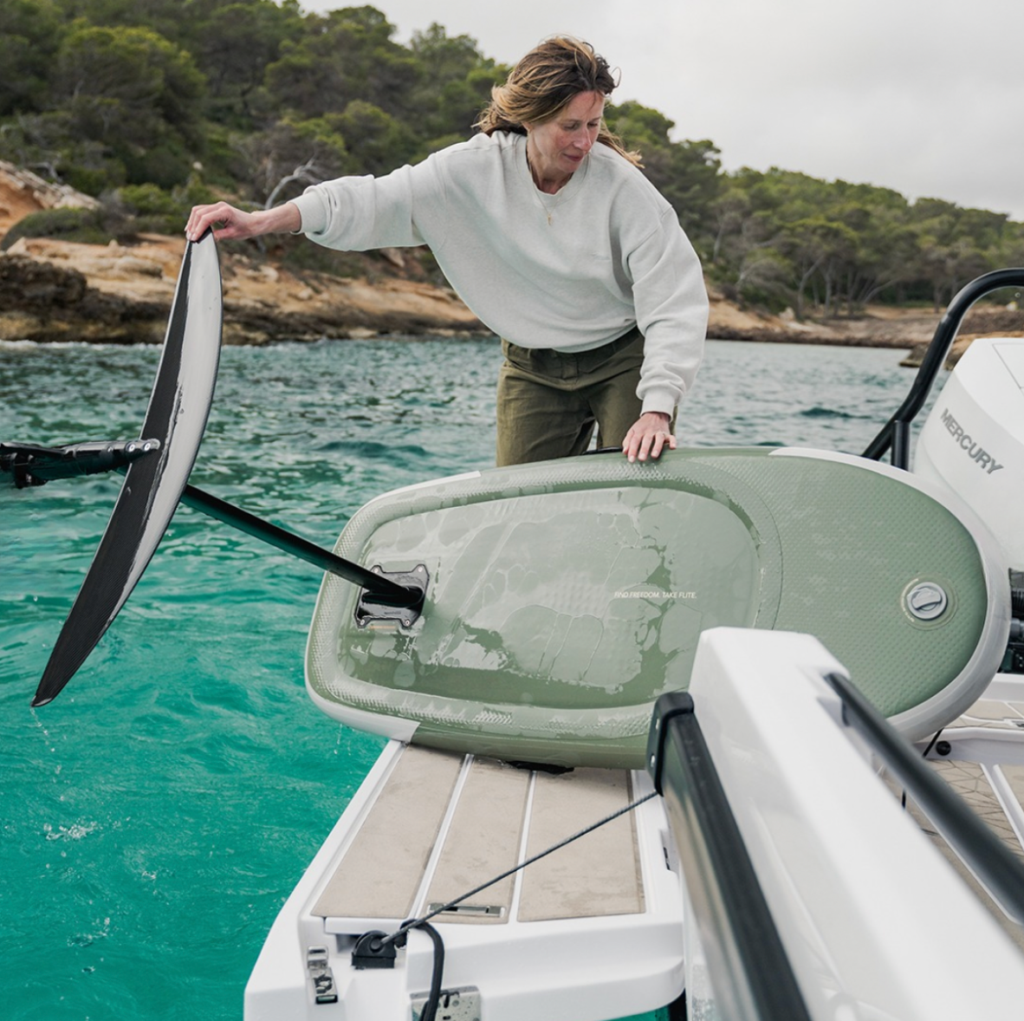 Soft Top eFoil board being handled from a boat swim platform, showing practical dock and boat launch use for waterfront owners.