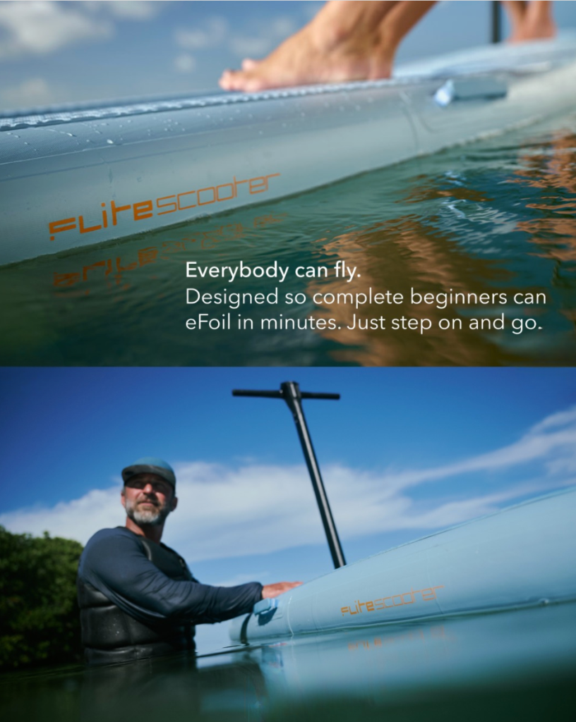 Close-up of the FliteScooter 2026 inflatable eFoil board floating in shallow water, showing stable high-volume construction for beginner riders.